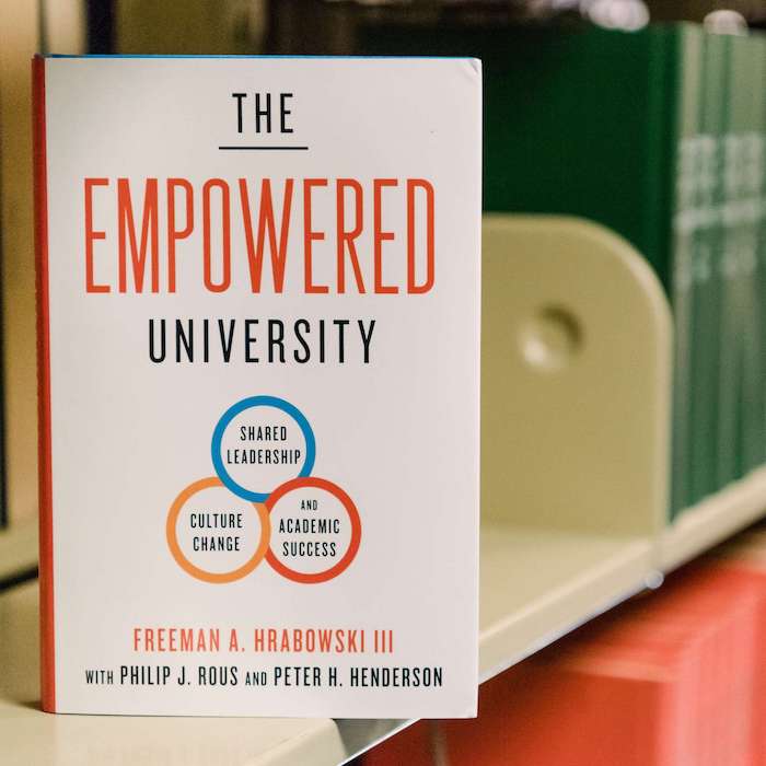 A photograph of the cover of The Empowered University on a book shelf.