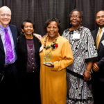 Group of people pose with Legends of Excellence award