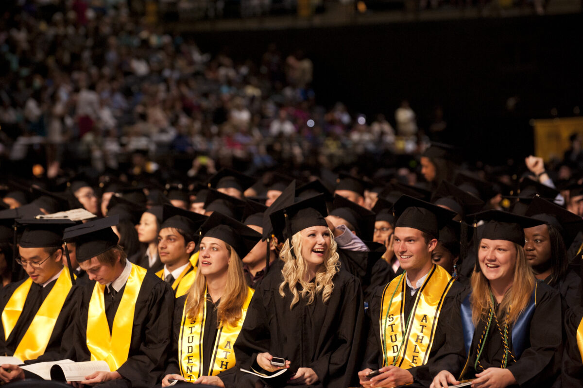 graduating students laugh at undergrad commencement