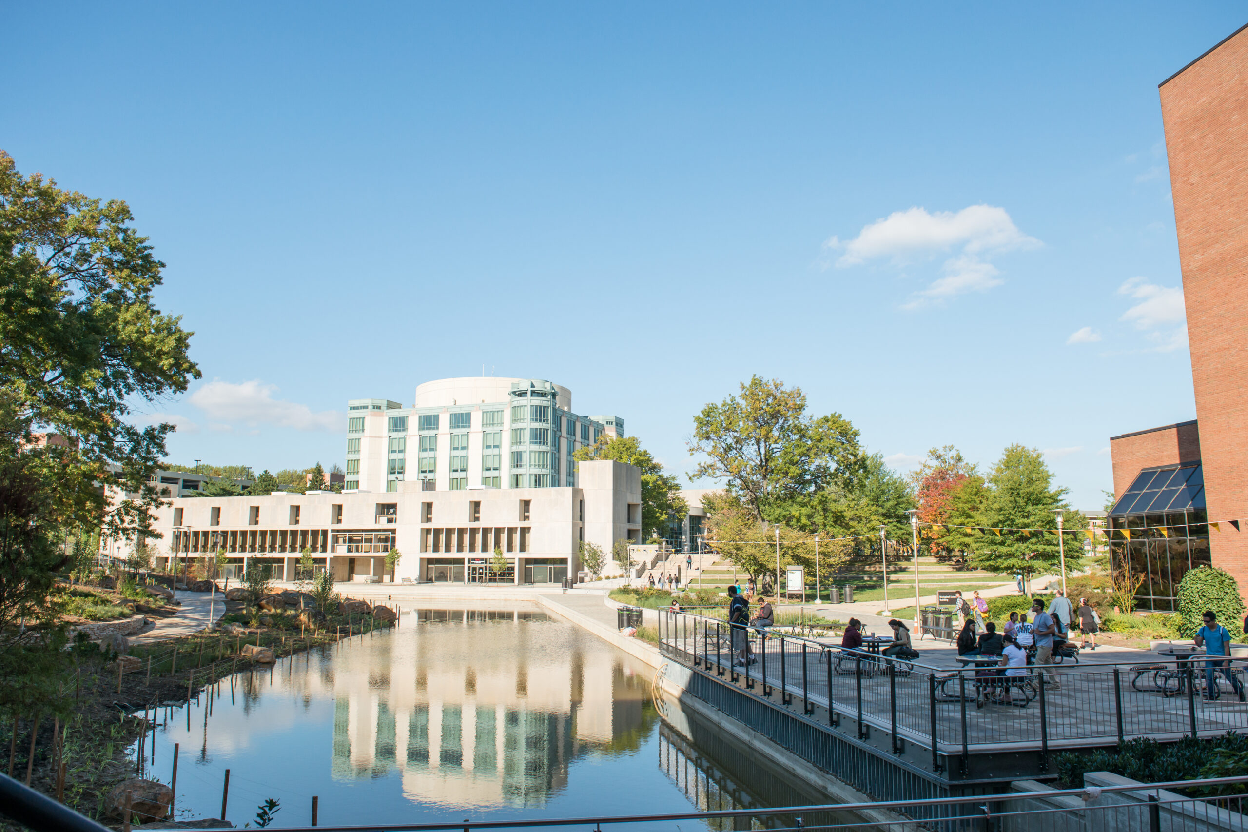 UMBC's library building reflecting in the campus pond on a bright sunny day.