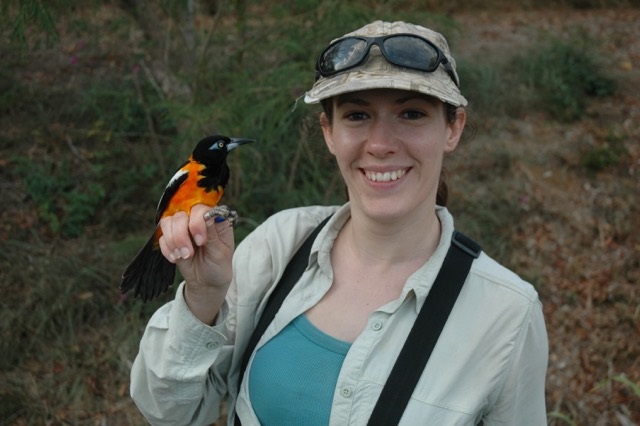 woman in outdoor gear holding a bird