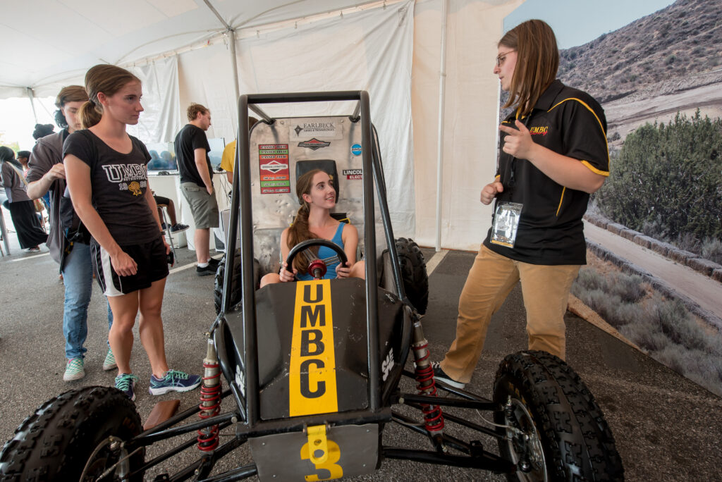 Festival-goer tries out UMBC Racing's Baja vehicle.