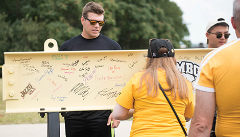 Alumni sign a beam that will be placed in UMBC’s new state-of-the-art Events Center.