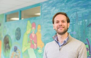 Man standing in front of biology mural