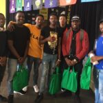 Group of male students posing with green care packages