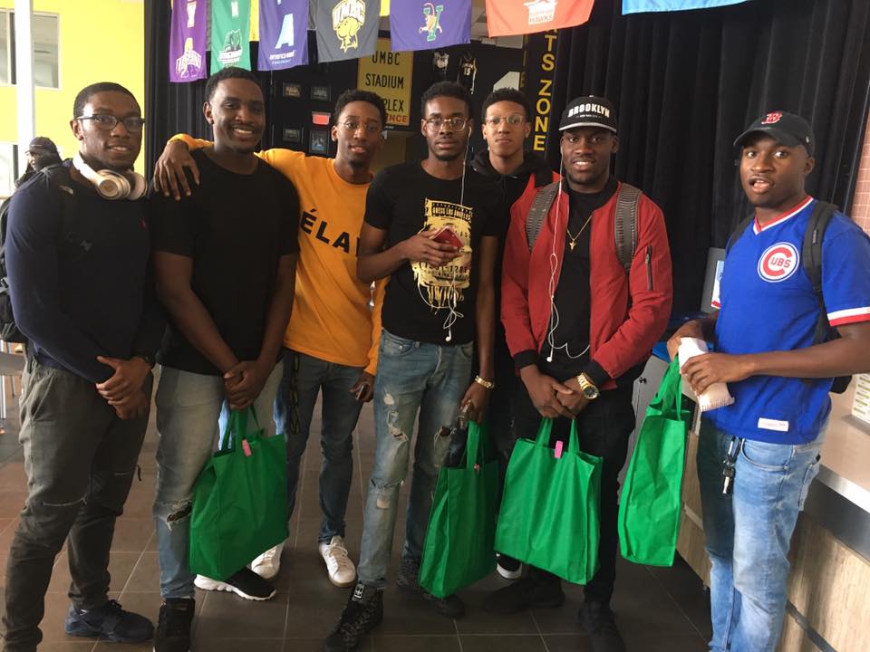 Group of male students posing with green care packages