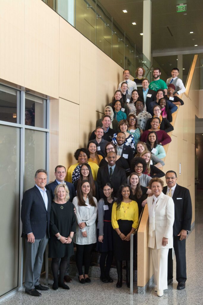 A large group of people fills a long staircase, smiling for a portrait.