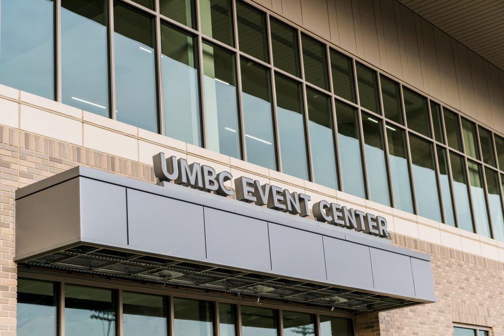 Shot of event center building with sign that says "UMBC Event Center" and clean glass windows.