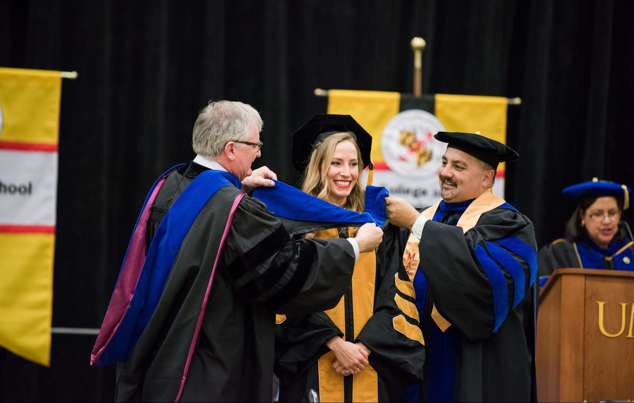 Student receives her PhD in hooding ceremony with faculty member and provost