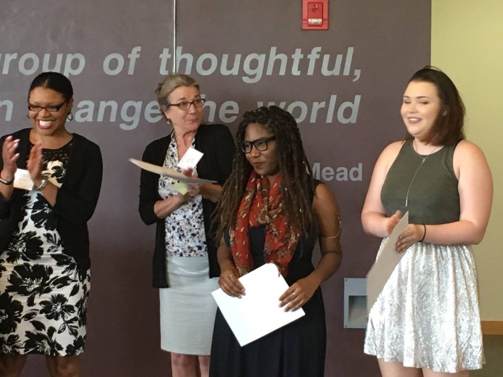 Ciara Christian with three other women, holding papers and clapping.