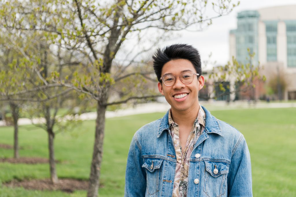 Portrait of Emmanual Mones outside. The UMBC Library can be seen in the background.