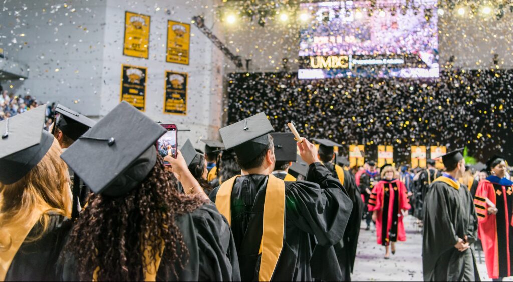 Graduates in black and gold caps and gold celebrate UMBC's spring 2018 graduate school commencement