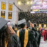 Graduates in black and gold caps and gold celebrate UMBC's spring 2018 graduate school commencement