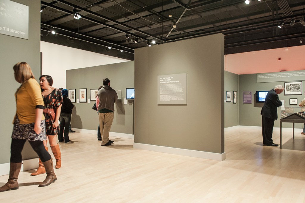 A gallery with several people viewing works of art