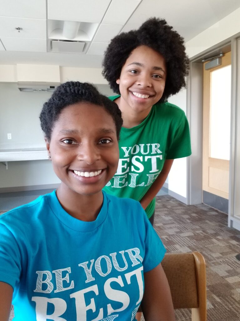 Two young women smile in a selfie, wearing 