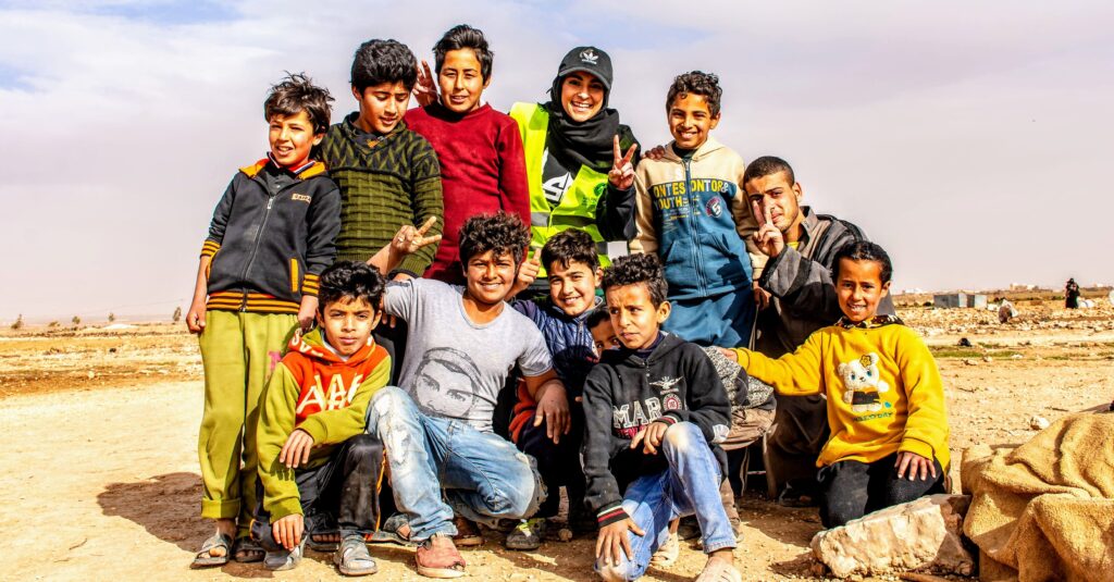 Maheen posing with boys from Syrian refugee camp after handing out soccer jerseys she helped to fundraise.