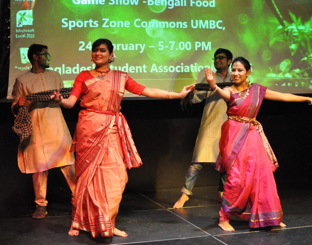 Four dancers demonstrate movements from Bangladeshi cultural traditions, in Bengali clothing.