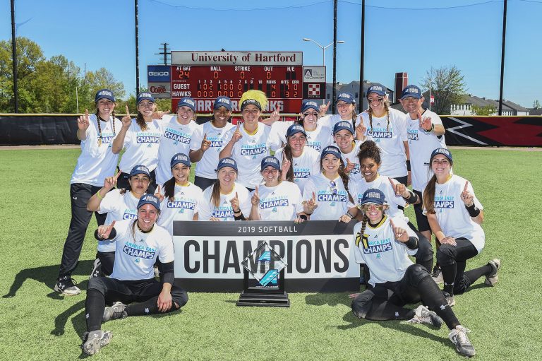 UMBC softball poses with America East trophy.