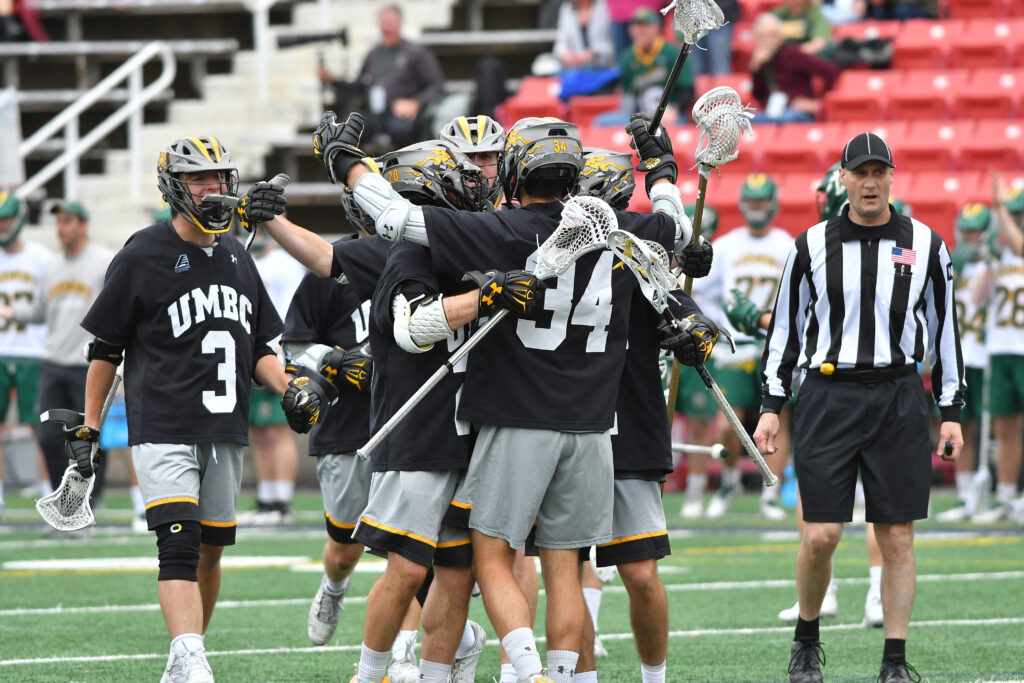 Men's lacrosse players embrace on the field, after a big victory