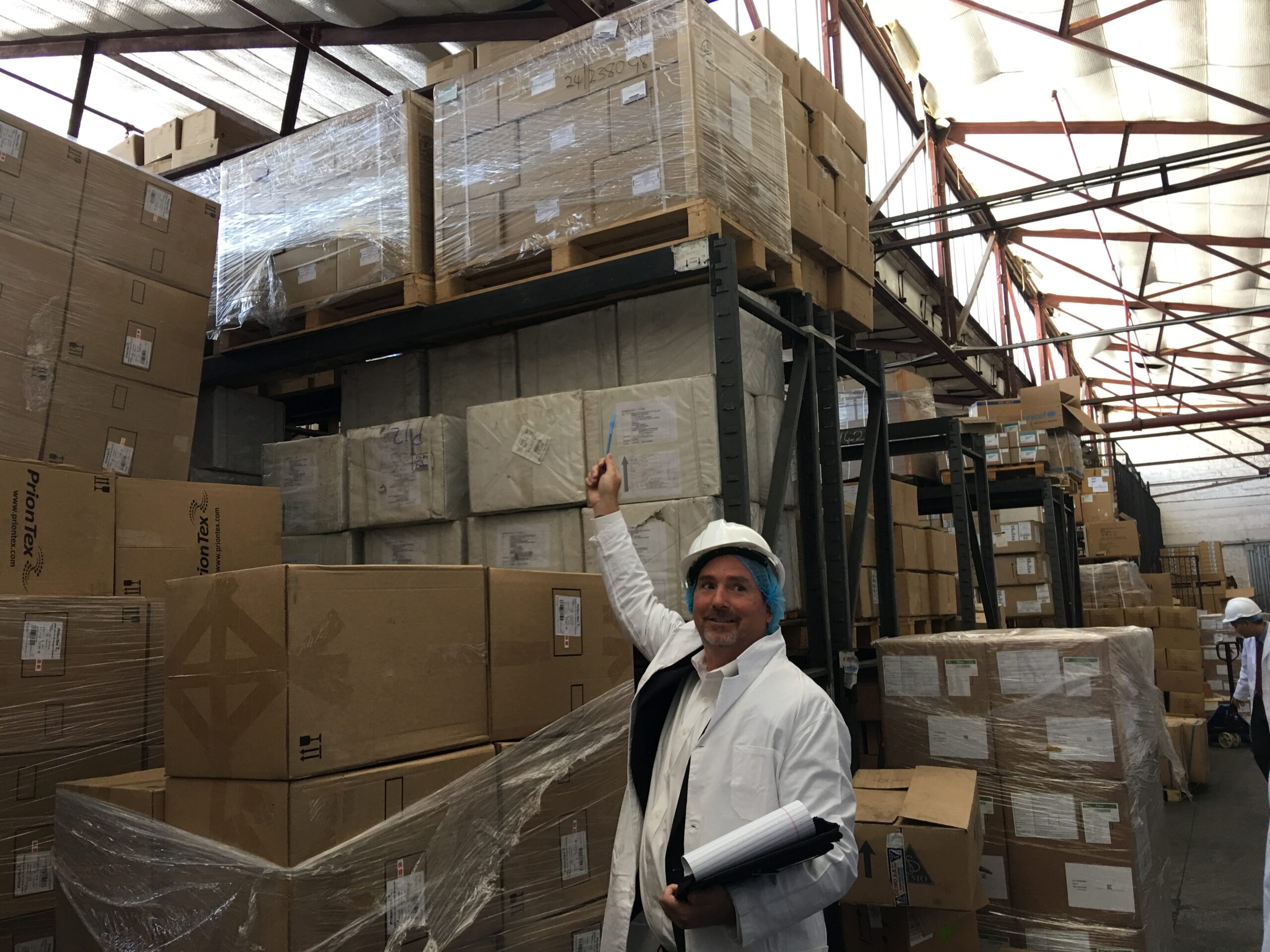 Shelsby visits the Central Medical Warehouse in Harare, Zimbabwe. Here, he's pointing to health commodities that his program supplied. Photo courtesy of Shelsby.