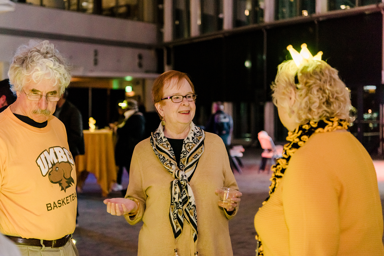 Three people in UMBC colors at the Light City UMBC Reception