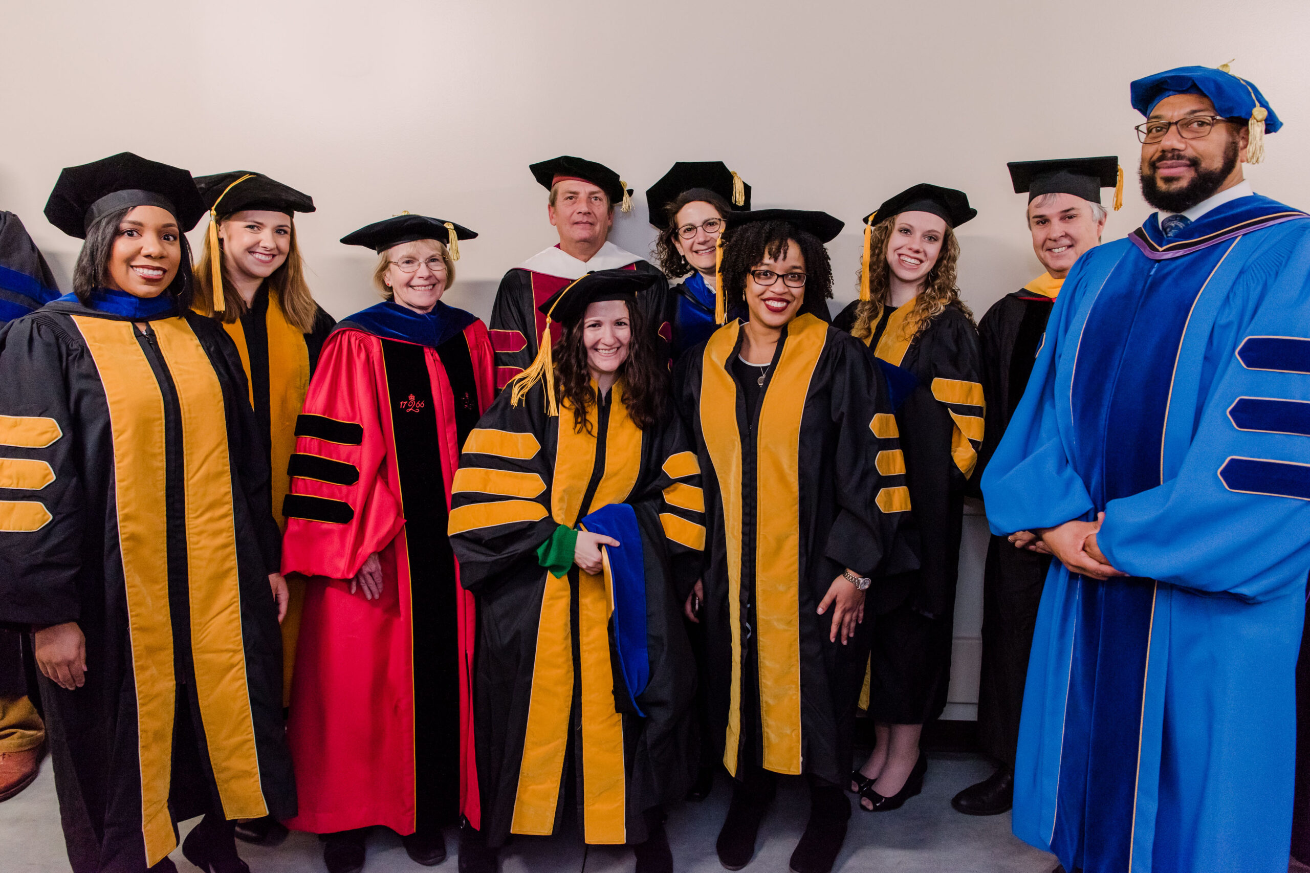 professors in graduation garb pose together