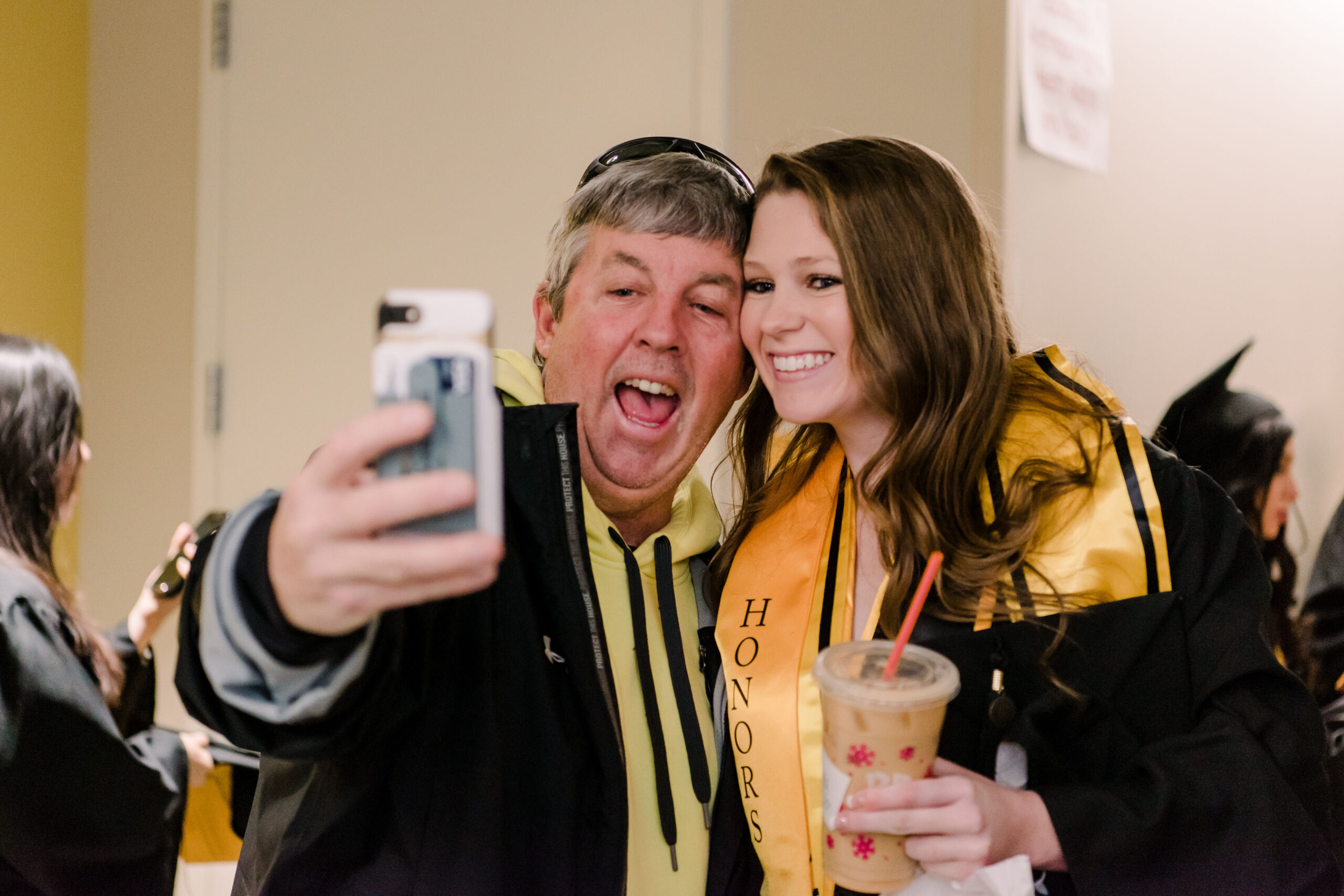 man and graduating student take a selfie together