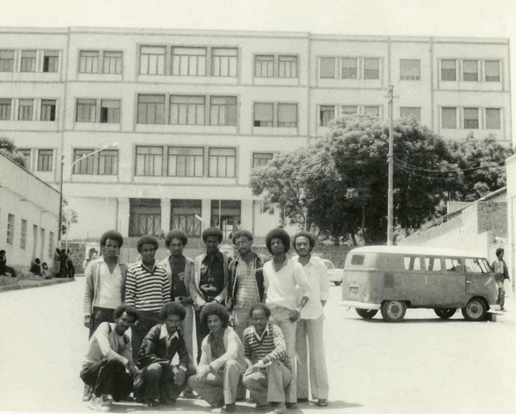 Black and white photo of group of black men posing in front of building