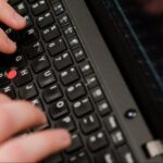 Person's hands typing on a keyboard.