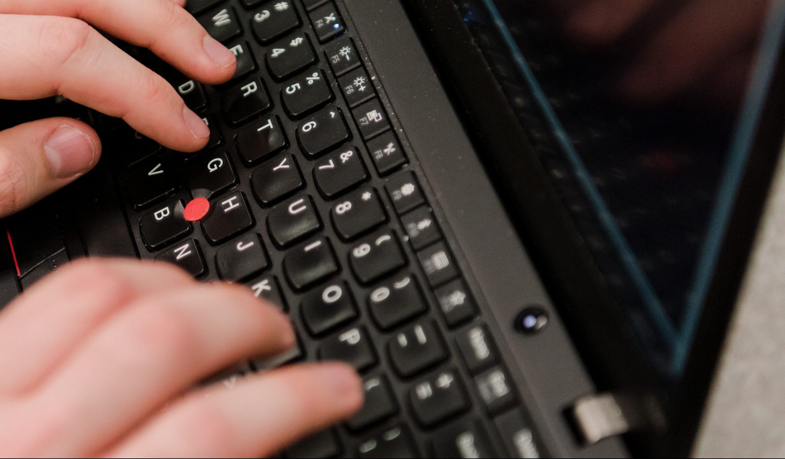 Person's hands typing on a keyboard.