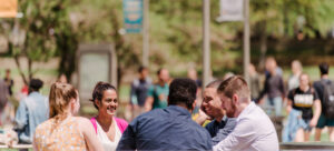 students sitting together at a table outside