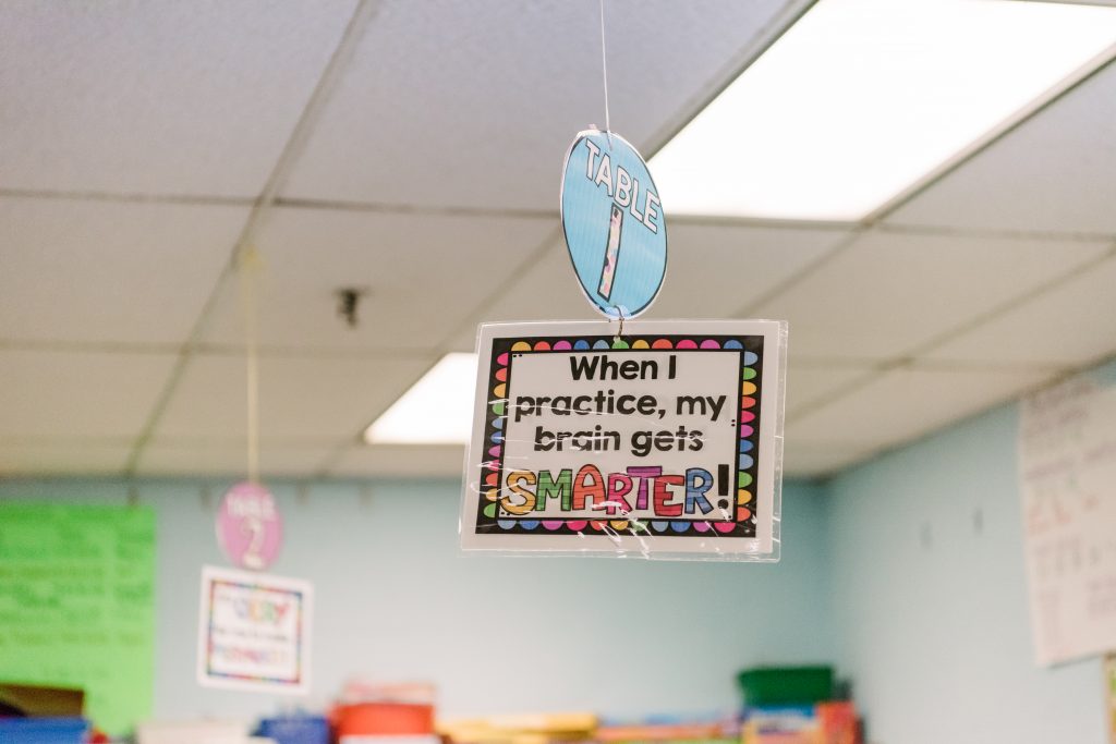 A colorful hanging sign that reads, "When I practice, my brain gets smarter!"