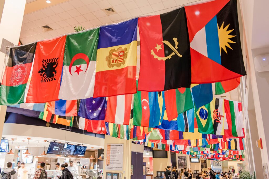 Rows of international flags hang from a ceiling.
