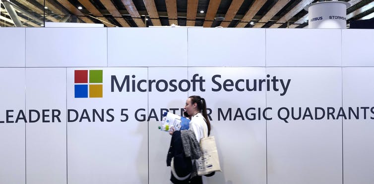 A woman walks in front of the Microsoft stand 