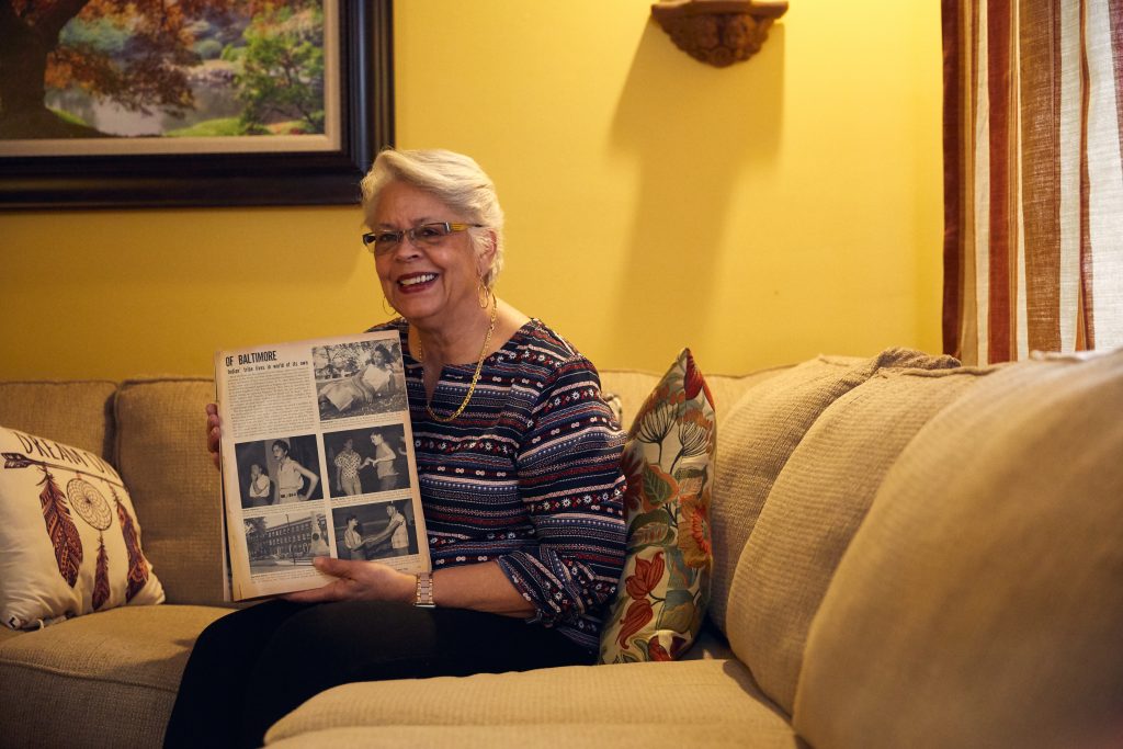 a woman on a couch holding of book of photos