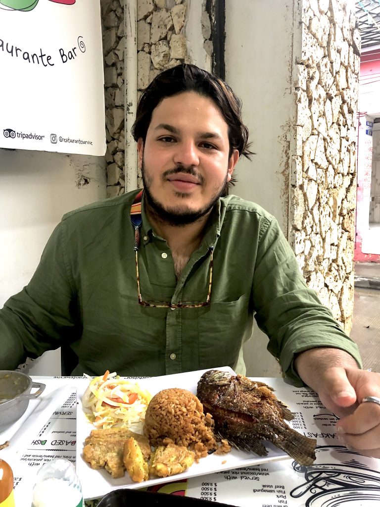 Cano eating a typical Cartagenian dish, featuring fish, rice, and vegetables. 