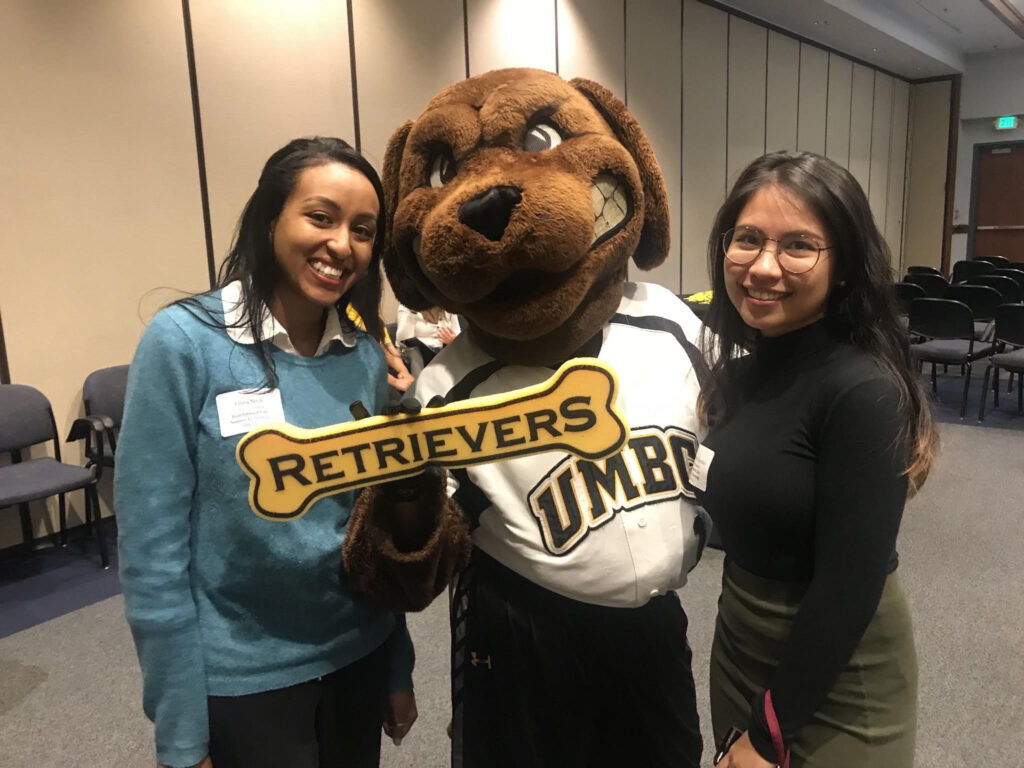 Two students flank a dog mascot