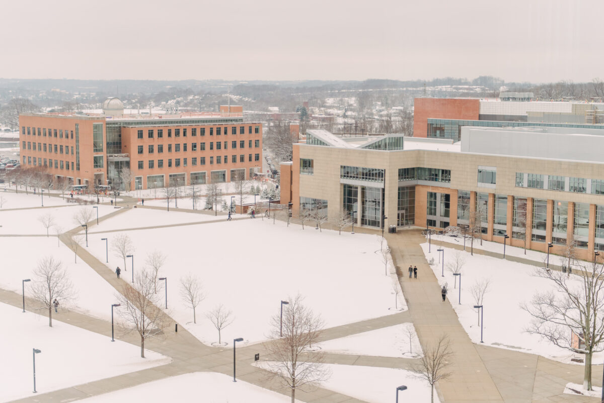 The UMBC physics building fronted by a large quad dusted in snow