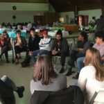 A group sits in a circle of chairs.