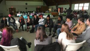 A group sits in a circle of chairs.