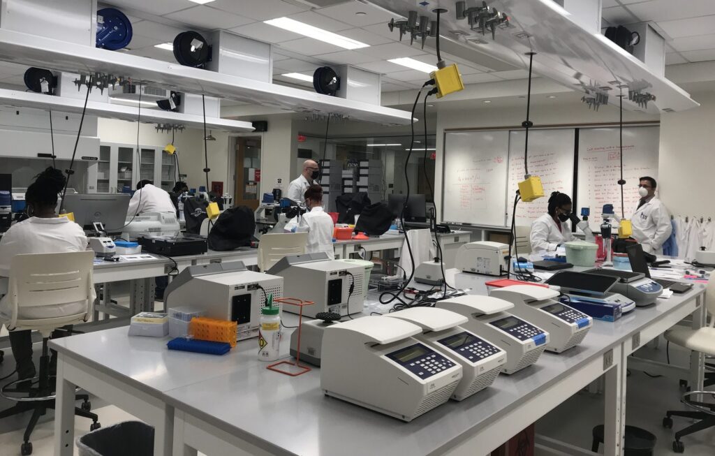 open laboratory space with lots of machines and a handful of students at work spread around the room