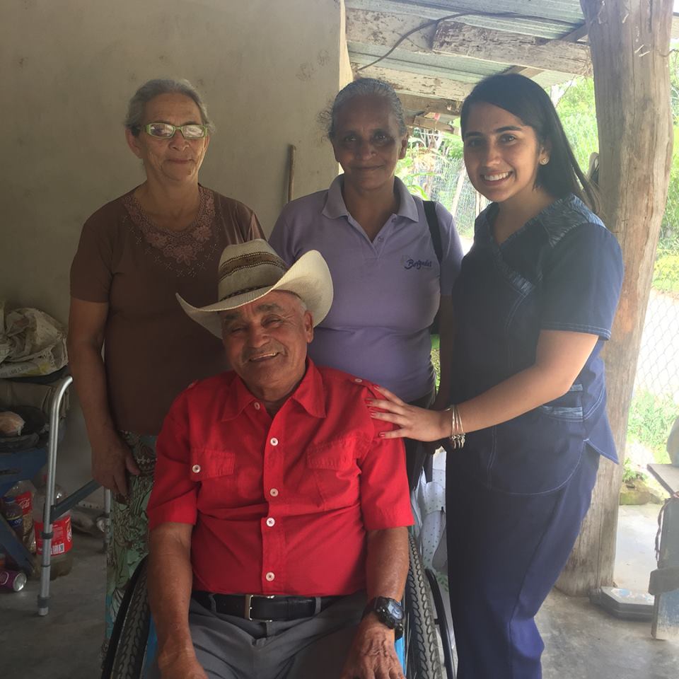 Student in healthcare scrubs with three older Hondurans