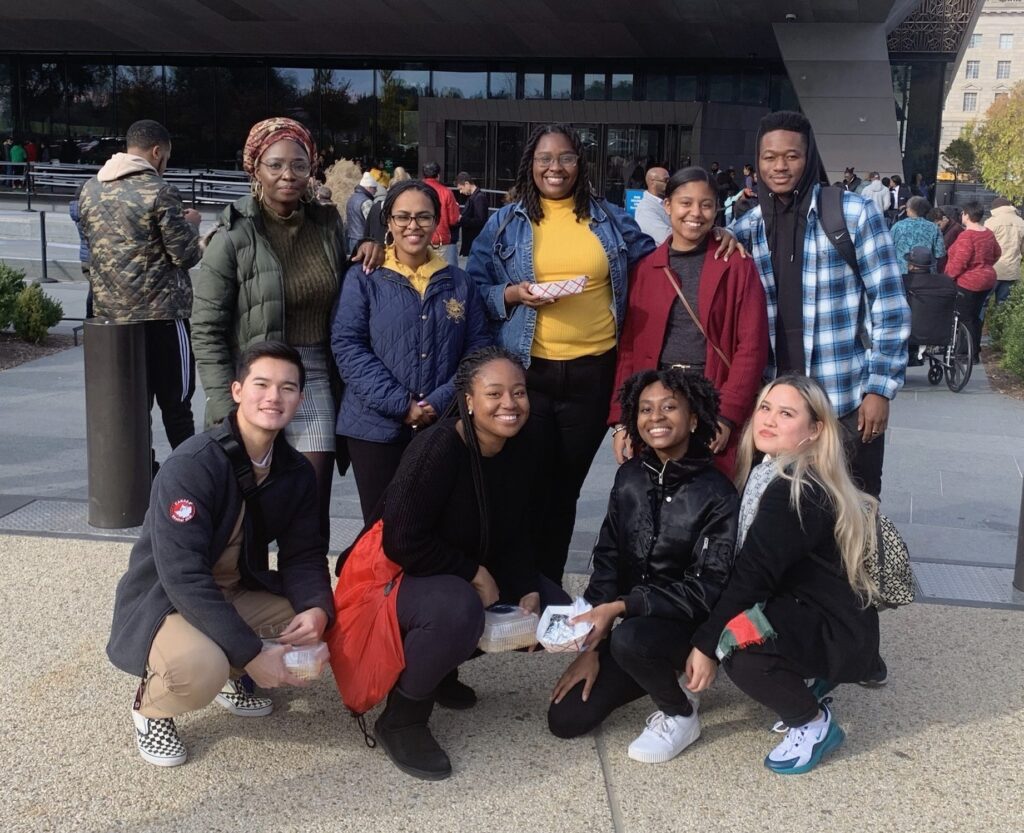 Nine students posing for a group photo outdoors