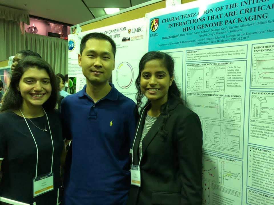 Three researchers in a busy poster hall