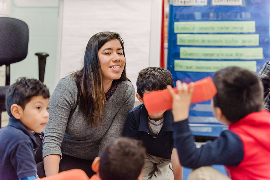 a young woman working with children in a classroom
