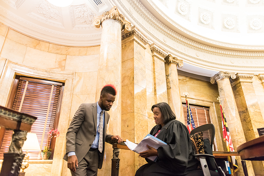 two people overlooking documents in a courtroom