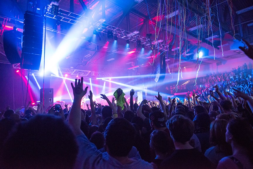 Kesha performing at an exciting live music event for quadmania with lights and a big audience