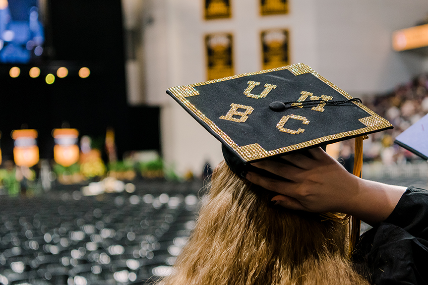 A young woman wearing a UMBC graduation cap