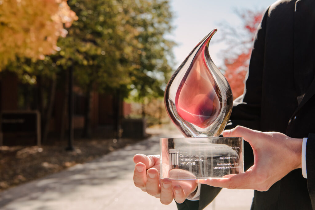 Person holds glass trophy in the shape of a flame