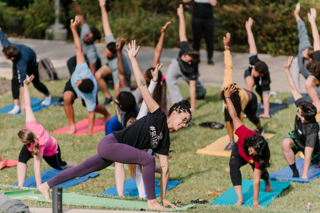 A group of people doing yoga on the field